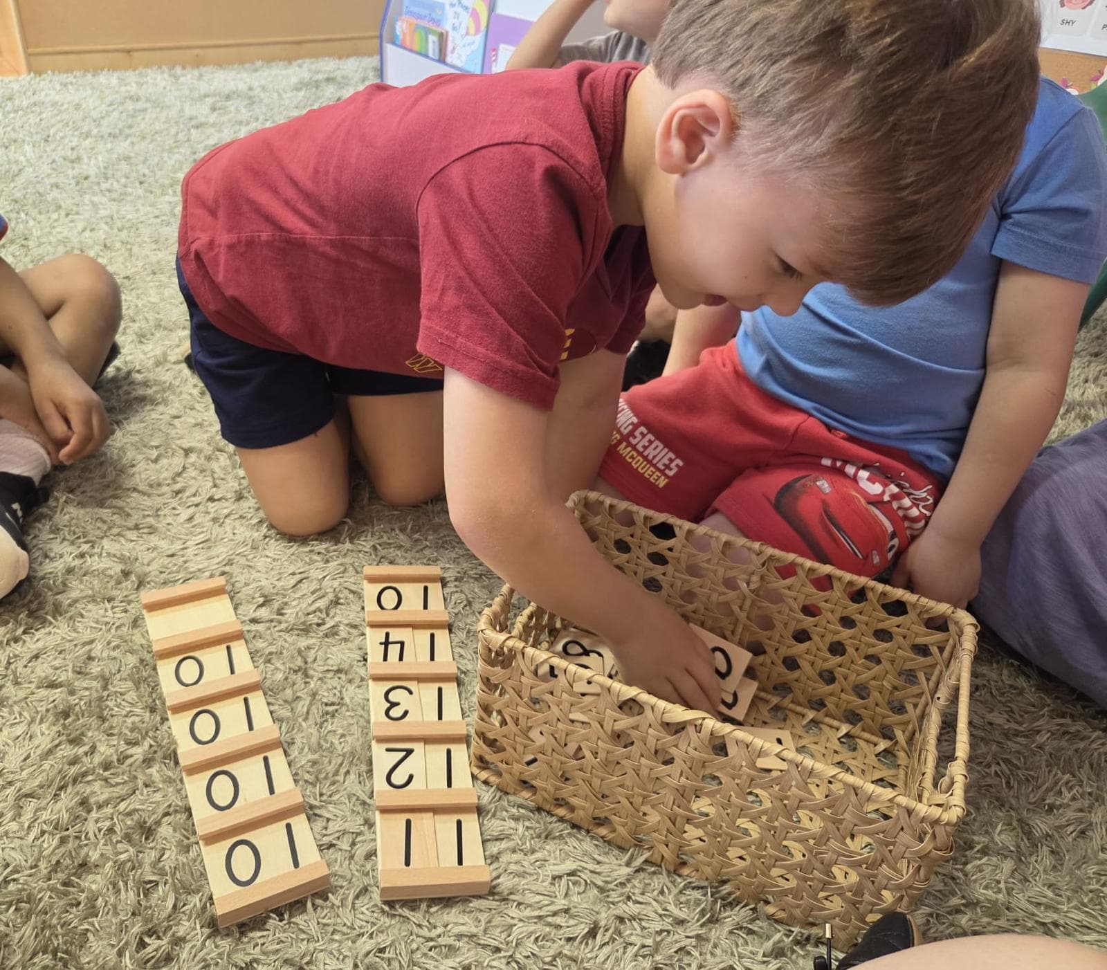A preschooler matching wooden number tiles during a math activity